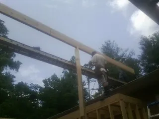 Carpenter setting a ridge beam over a new addition frame — Ice Dam Removal by Roofing Brothers in Zionsville