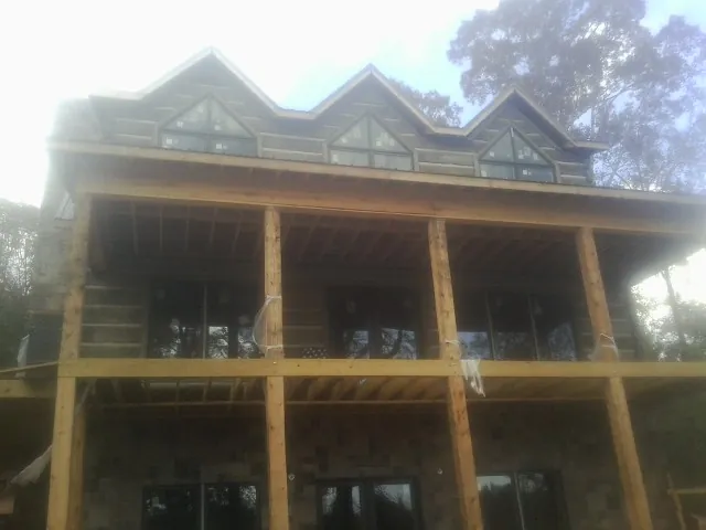 Dormers and porch framing on a large log home under construction — Roof Coating work by our crew in Zionsville